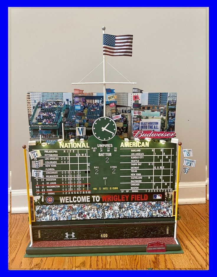 a baseball scoreboard with an american flag on top and other sports memorabilia in the background