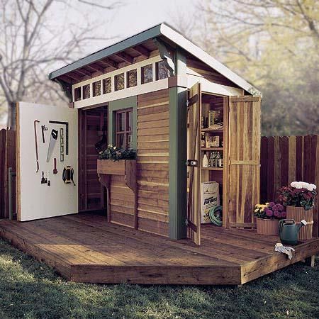 a small wooden shed sitting on top of a lush green field