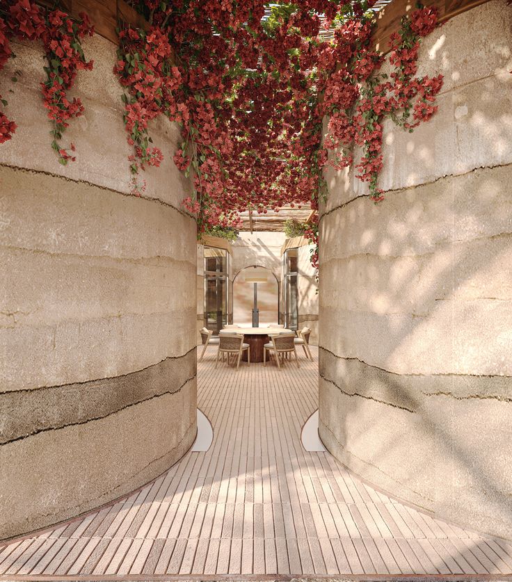 the walkway is lined with red flowers on it's sides and has benches under them