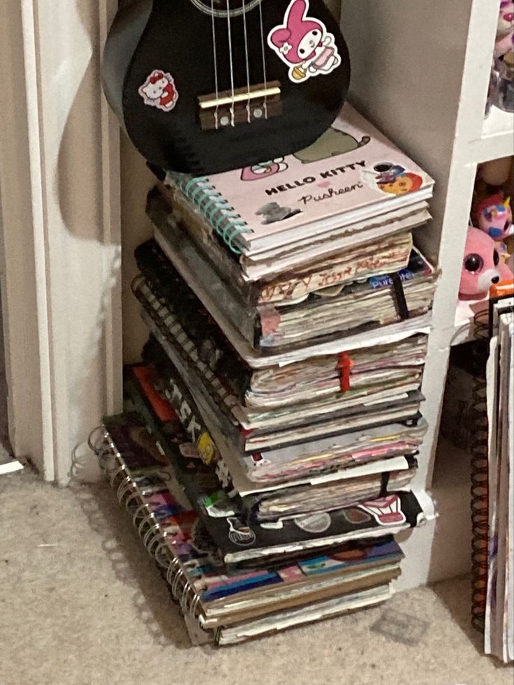 a guitar sitting on top of a stack of magazines