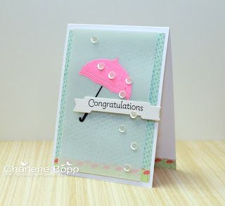 a card with an umbrella and congratulations message on the front, sitting on a table