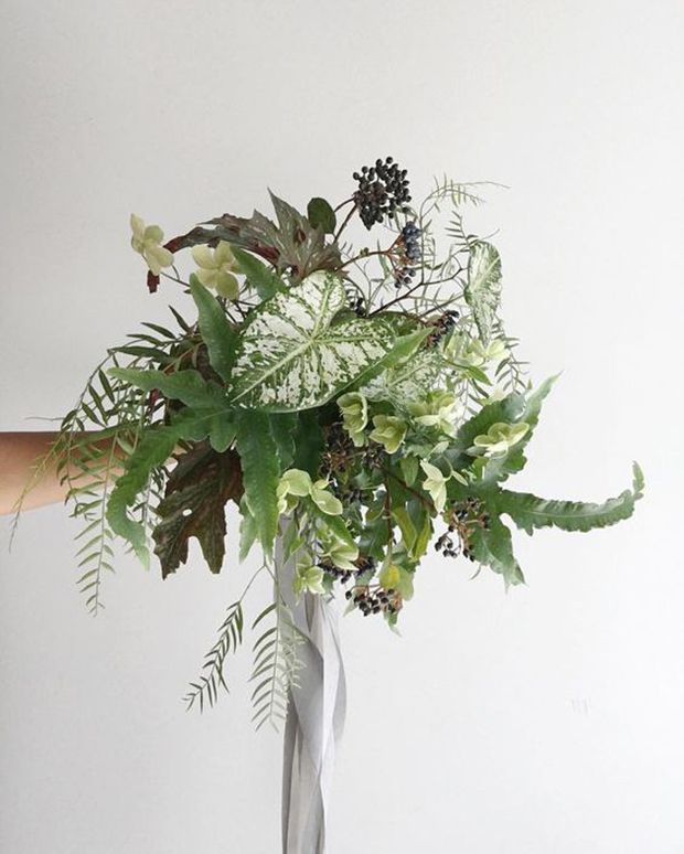 a vase filled with lots of green plants