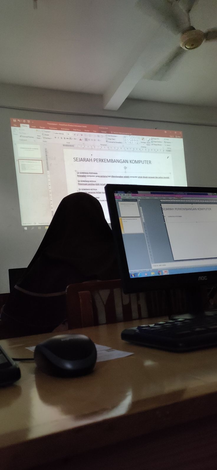 a computer monitor sitting on top of a wooden desk next to a keyboard and mouse