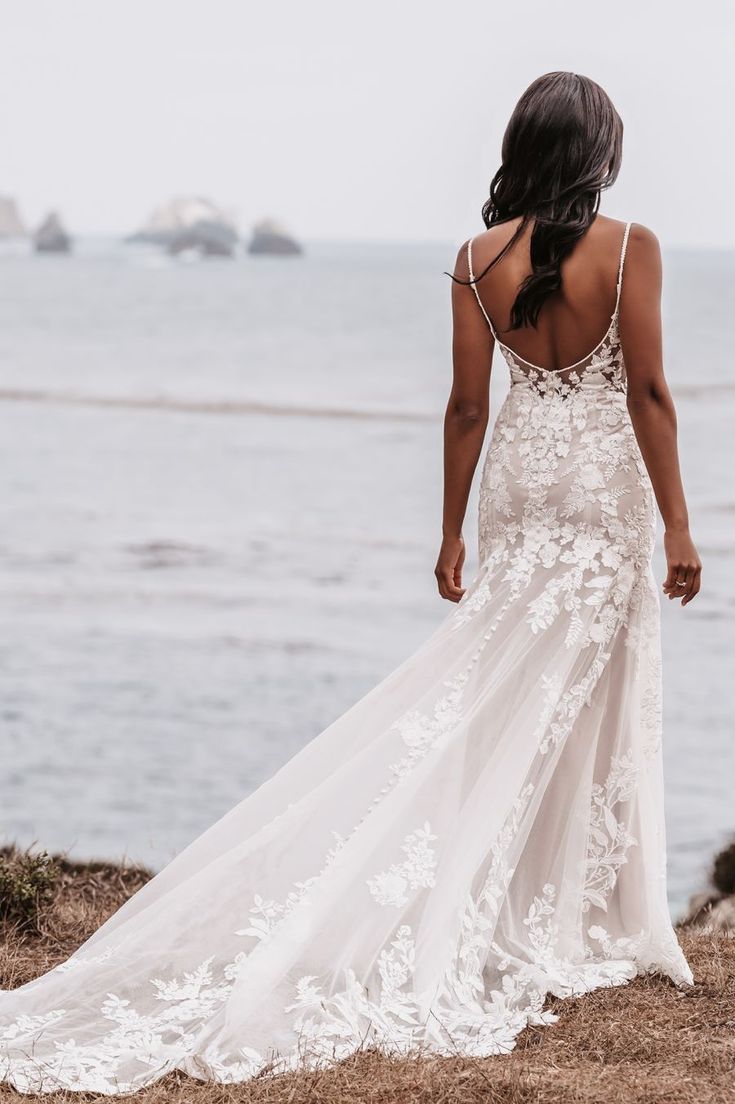 a woman in a wedding dress looking out at the ocean