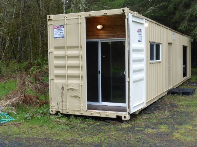 an outhouse made from shipping containers in the woods