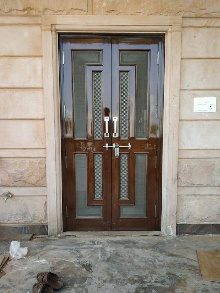 a pair of shoes sitting on the ground in front of a door with glass panels