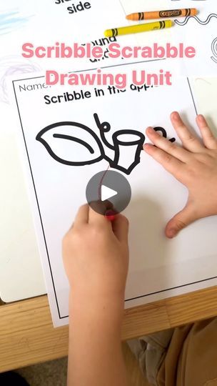 a child is drawing on a piece of paper with crayons and pencils