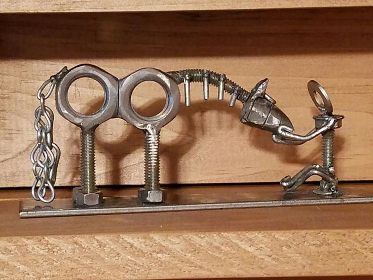 there is a metal horse made out of keys on a wooden shelf with chains hanging from it's sides