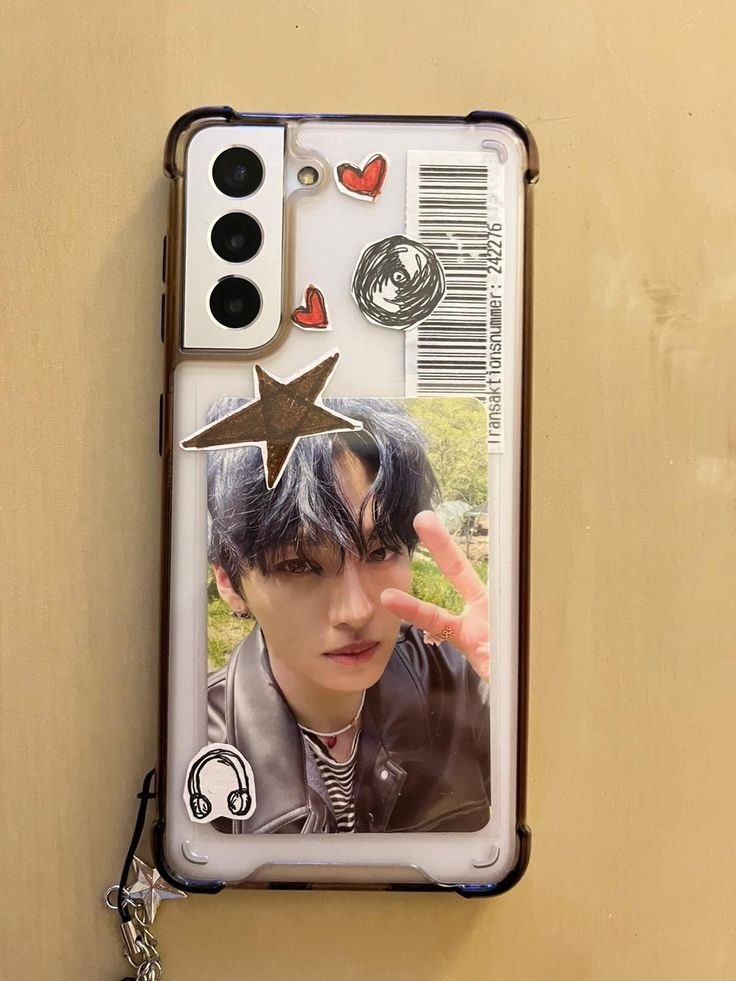 a cell phone case with an image of a boy on it and a star hanging from the back