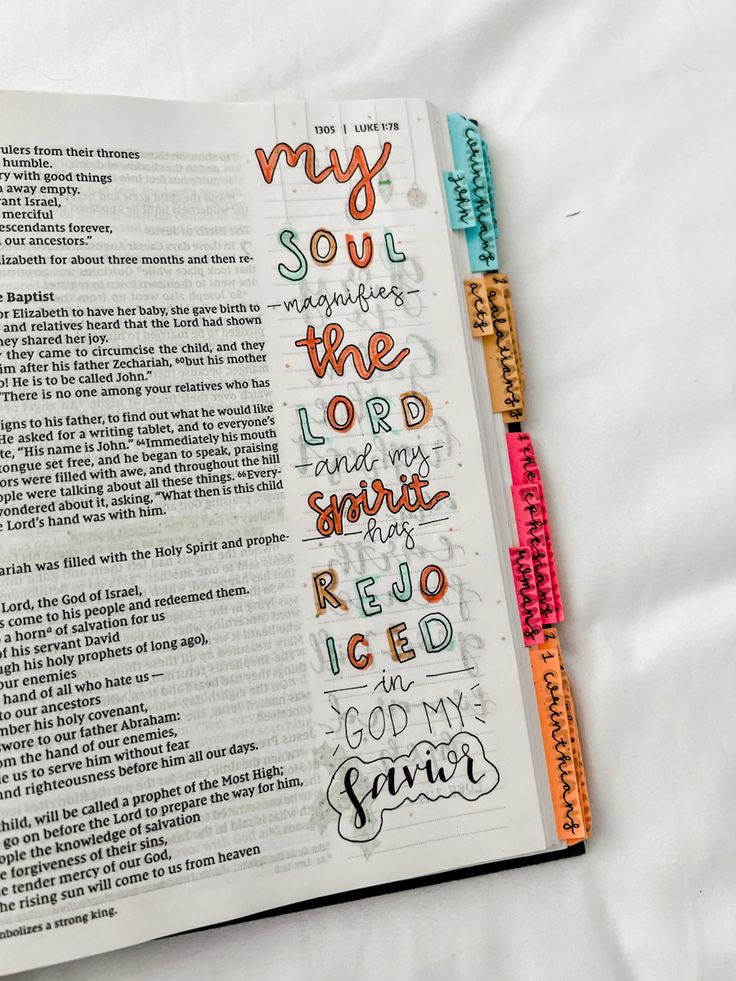 an open bible with colorful lettering on it