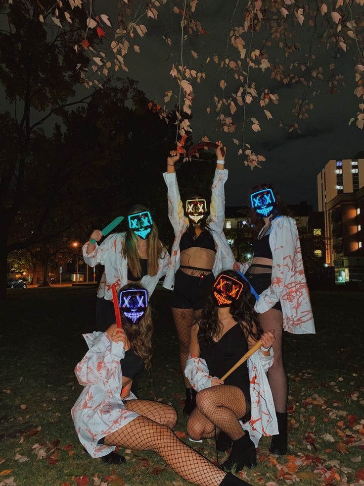 four people dressed up in costumes posing for the camera with masks on their heads and hands