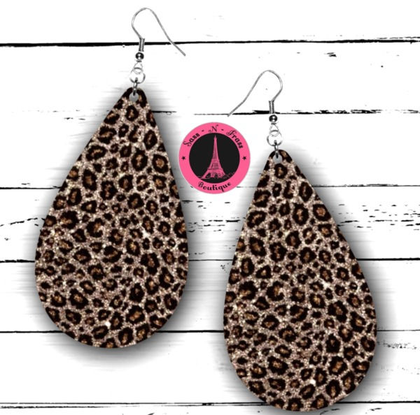 the leopard print tear earrings are shown on a white wooden background with a pink sticker