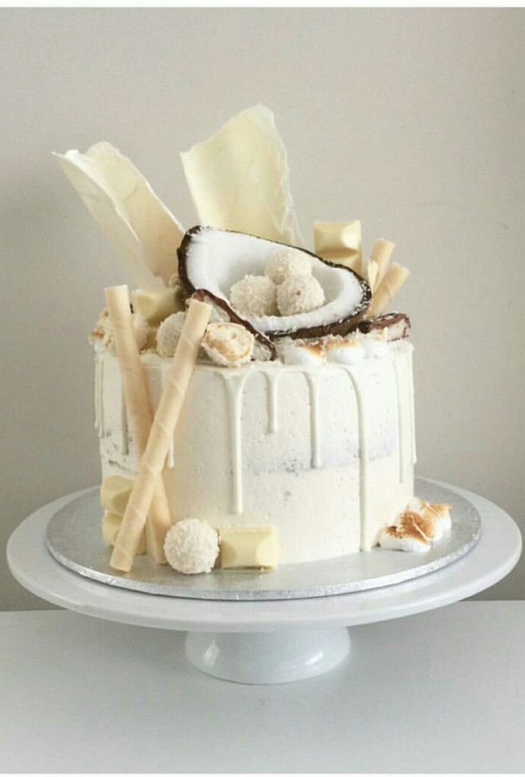 a white cake with coconuts and marshmallows is on a platter