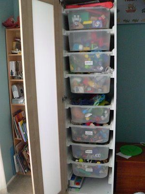 the closet is full of plastic bins and other storage containers for children's toys