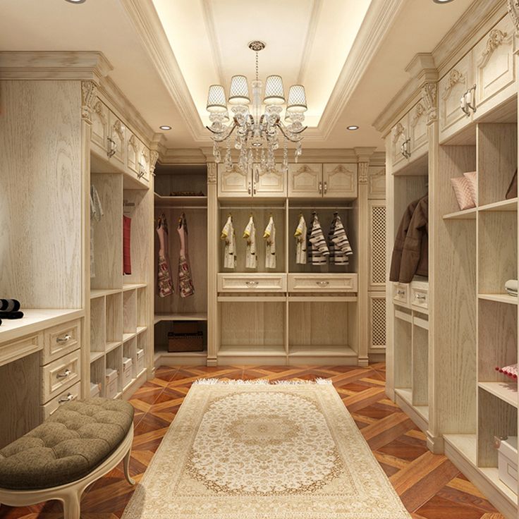 an elegant walk in closet with chandelier and bench