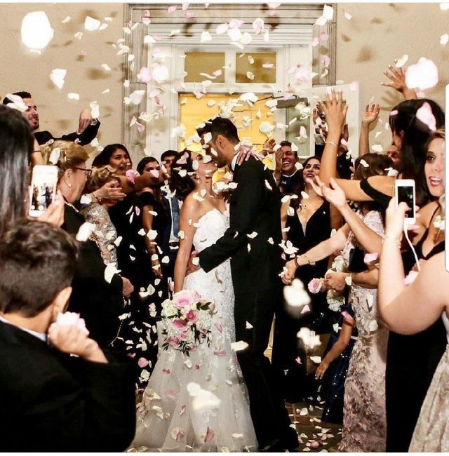 a bride and groom are surrounded by confetti as they walk down the aisle