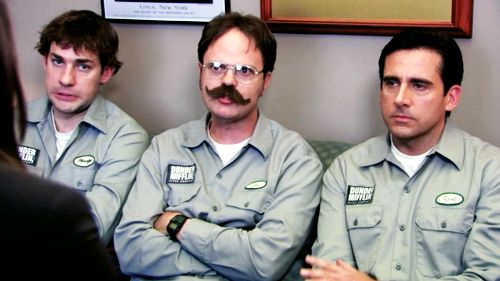 three men with mustaches are sitting on a couch