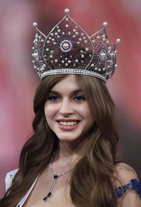 a woman wearing a tiara and smiling at the camera