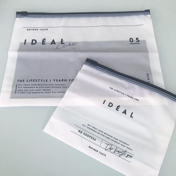 two envelopes sitting next to each other on top of a white table with writing on them