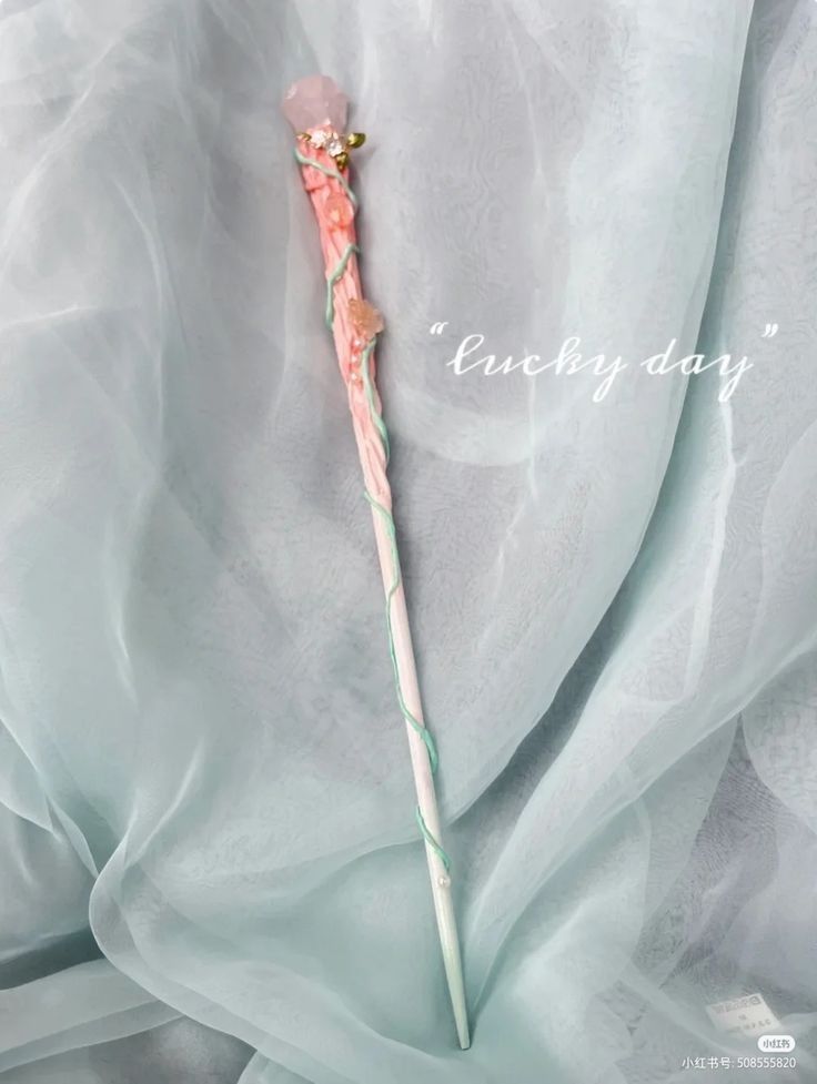 a pink and white umbrella laying on top of a bed covered in sheer fabric with the words lucky day written above it