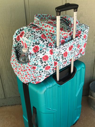 two pieces of luggage sitting next to each other on top of a cement floor near a wall