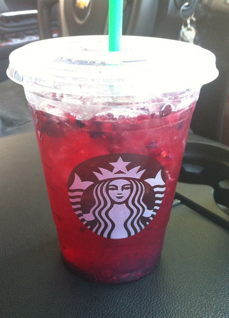 a red drink sitting on top of a table next to a green and blue straw