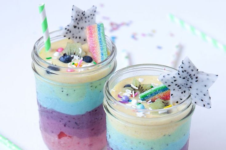 two glasses filled with different colored drinks and confetti on the rims,