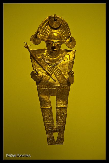 an ancient gold statue is shown against a yellow background