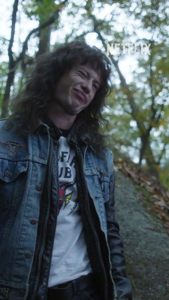 a man with long hair wearing a jean jacket