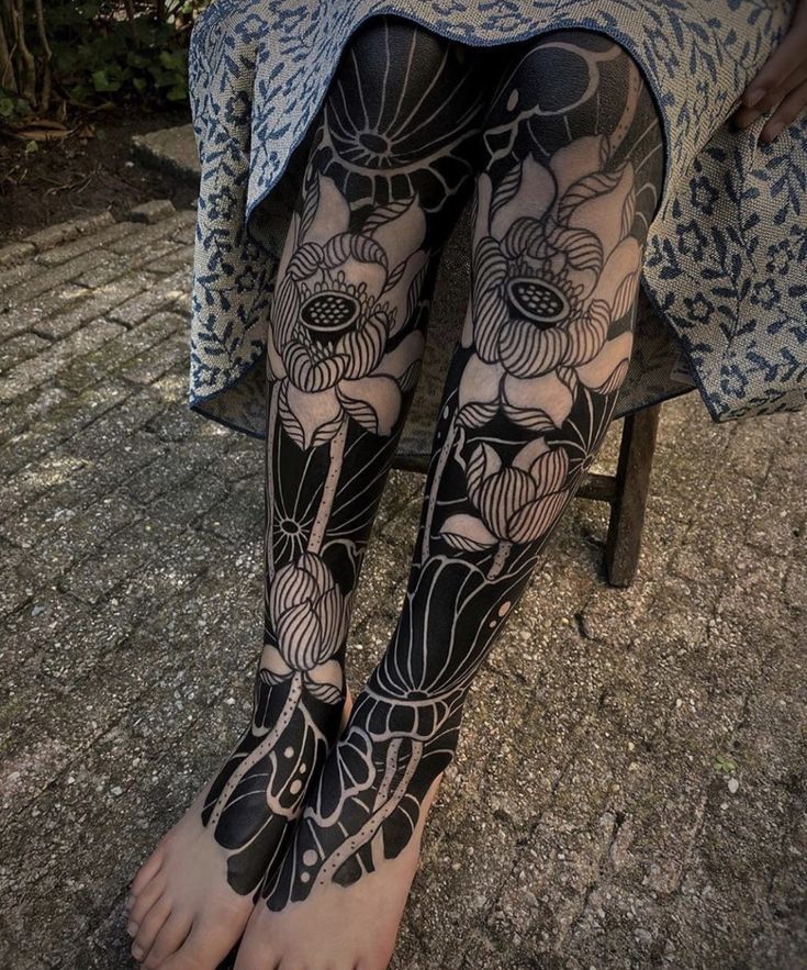 a woman's legs with black and white tattoos on them