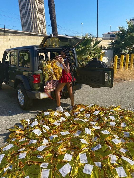 a woman sitting in the back of a pick up truck filled with yellow wrapped presents