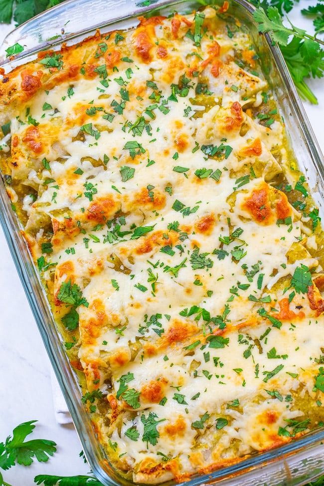 a casserole dish with cheese and parsley garnish on the side