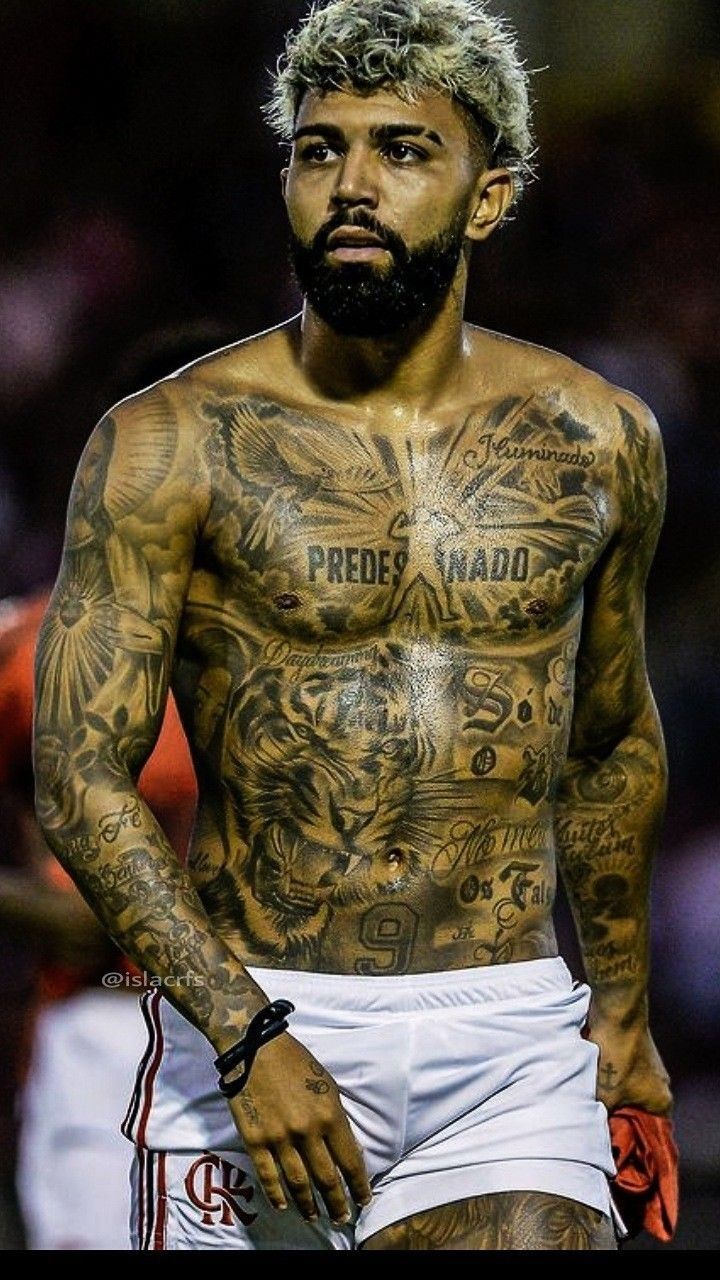 a man with tattoos on his body and chest is standing in front of the crowd