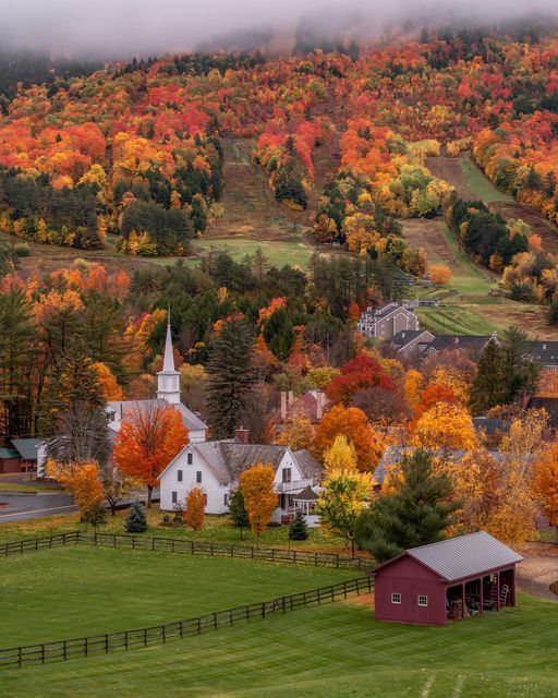 a small town surrounded by colorful trees in the fall