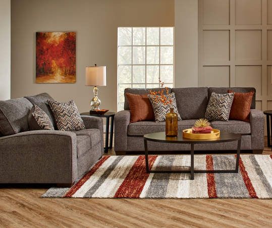 a living room with two couches, a coffee table and a rug on the floor