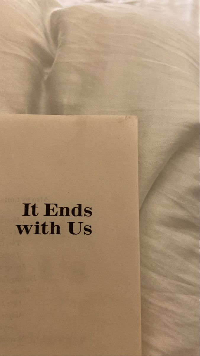 an open book with the words it ends with us on it sitting on a bed