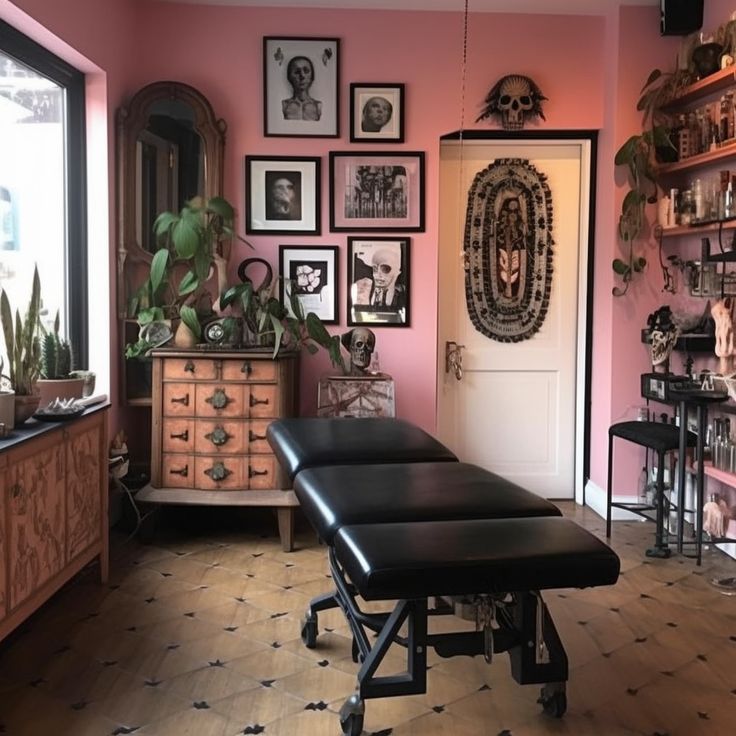 a room with pink walls and lots of pictures on the wall, including a black bench