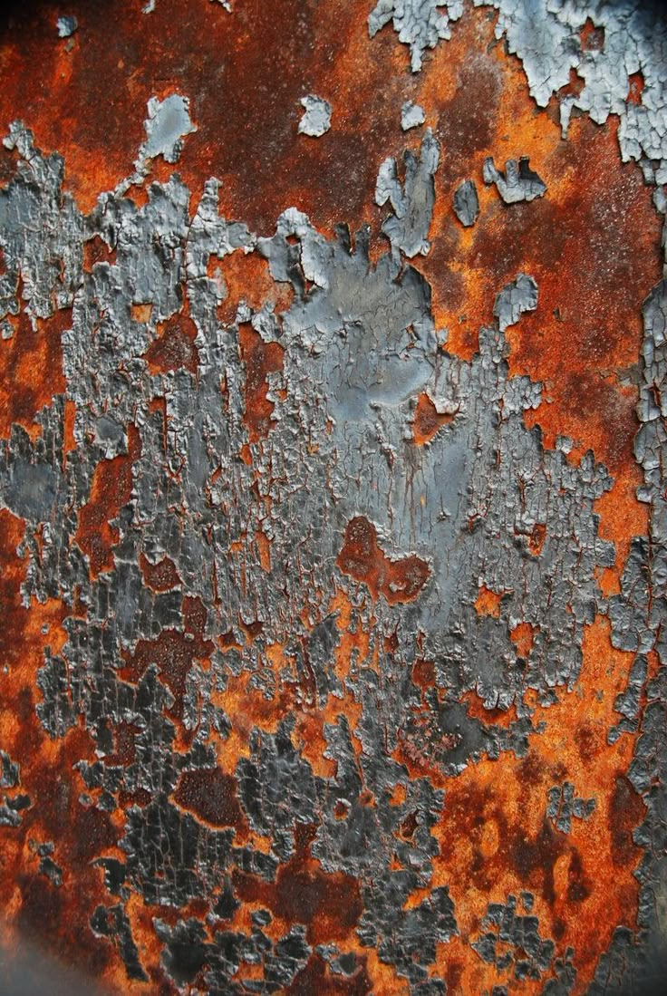 an old rusted metal surface with orange and white paint