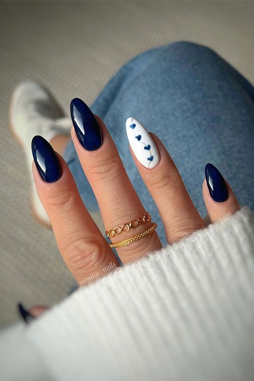 Dark navy blue almond-shaped nails with an accent white nail adorned with navy blue heart shapes Blue Autumn Nails, Biab Nails, Hoco Nails, Blue And White Nails, Dark Blue Nails, Navy Nails, Simple Fall Nails, November Nails, Summery Nails