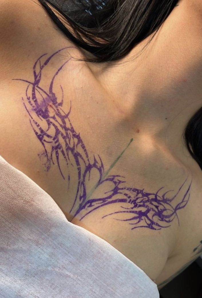 a woman with purple ink on her chest