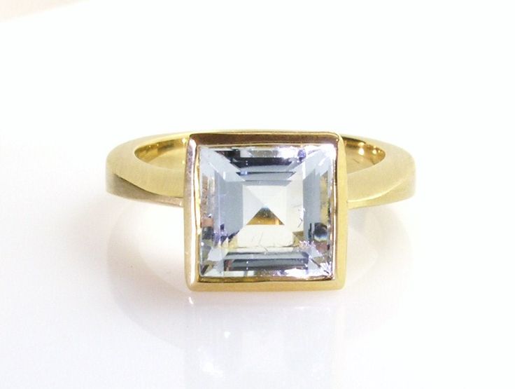 Square cut Fine aquamarine set on yellow brushed gold . Art Deco style . approx : 9 x 9 mm . Modern Gold Topaz Ring, Modern Gold Blue Topaz Ring, Silver Art Deco Aquamarine Rings, Square Aquamarine Ring, Fine Jewelry Aquamarine Ring In Octagon Shape, Classic Emerald-cut Aquamarine Jewelry, Luxury Art Deco Aquamarine Jewelry, Square Cut, Aquamarine Rings