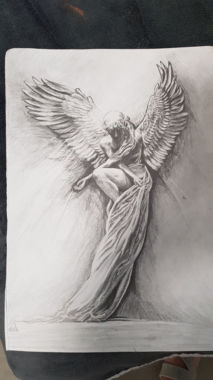 a drawing of an angel with its wings spread out, on a piece of paper