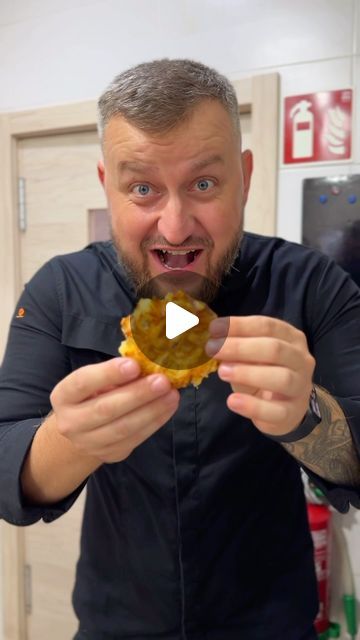 a man holding up a donut in front of his face and making a funny face