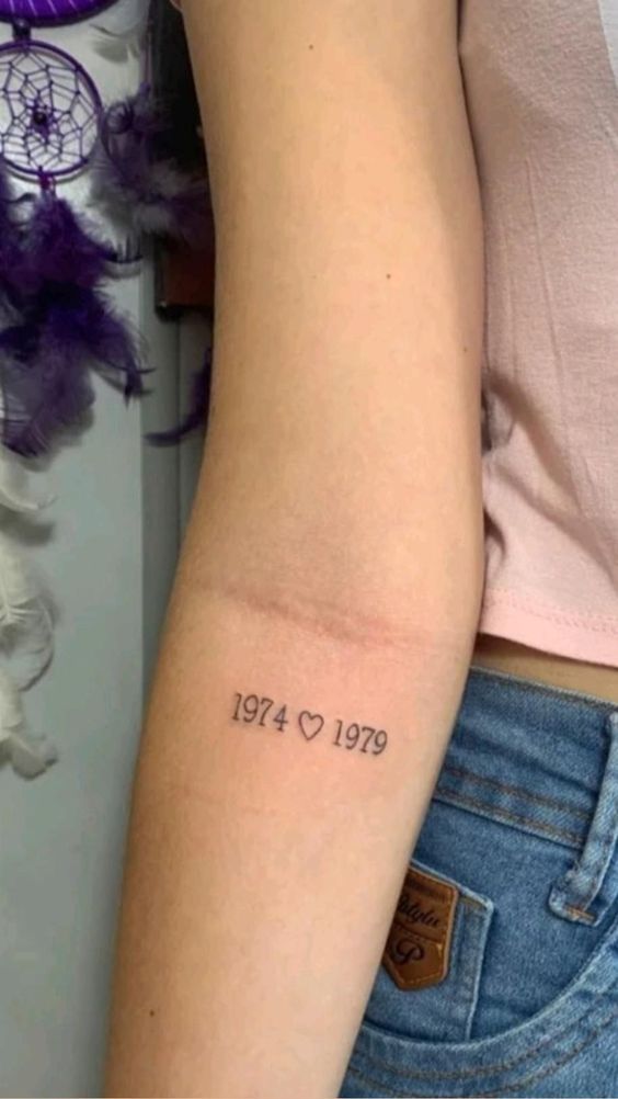 a woman with a tattoo on her arm that reads, 1974 - 1970 and the date