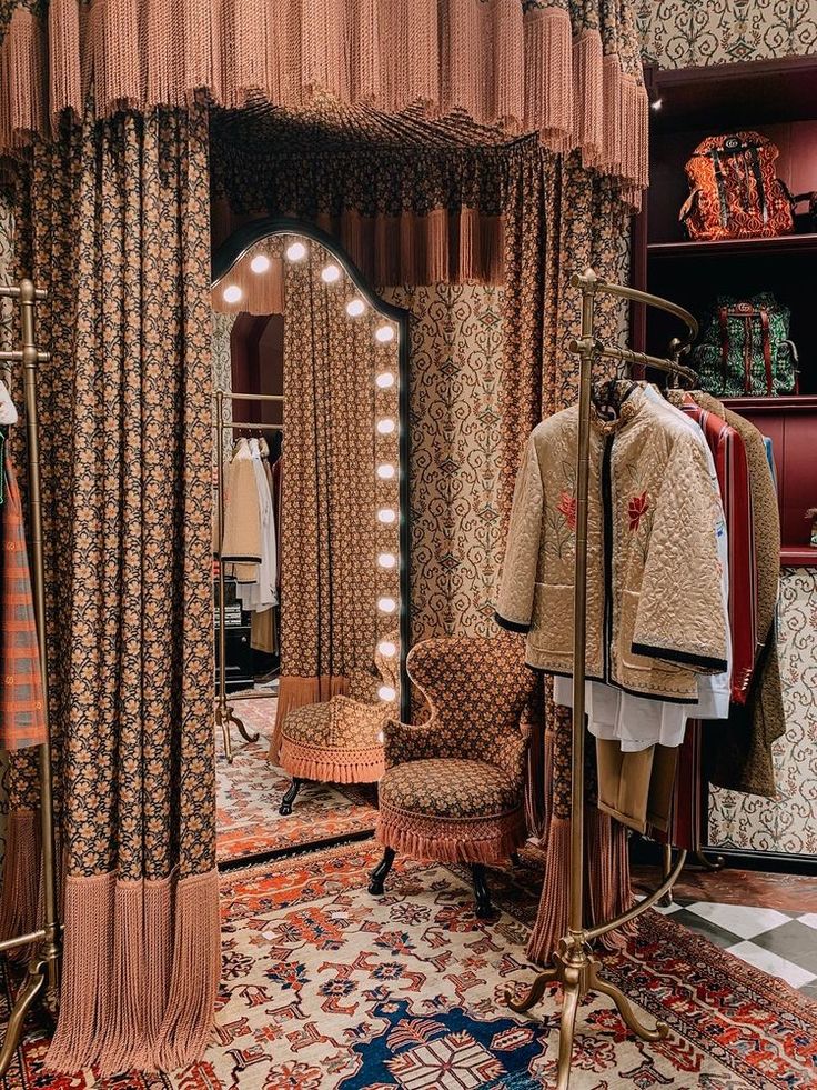 a room filled with lots of different types of clothing on display in front of a mirror