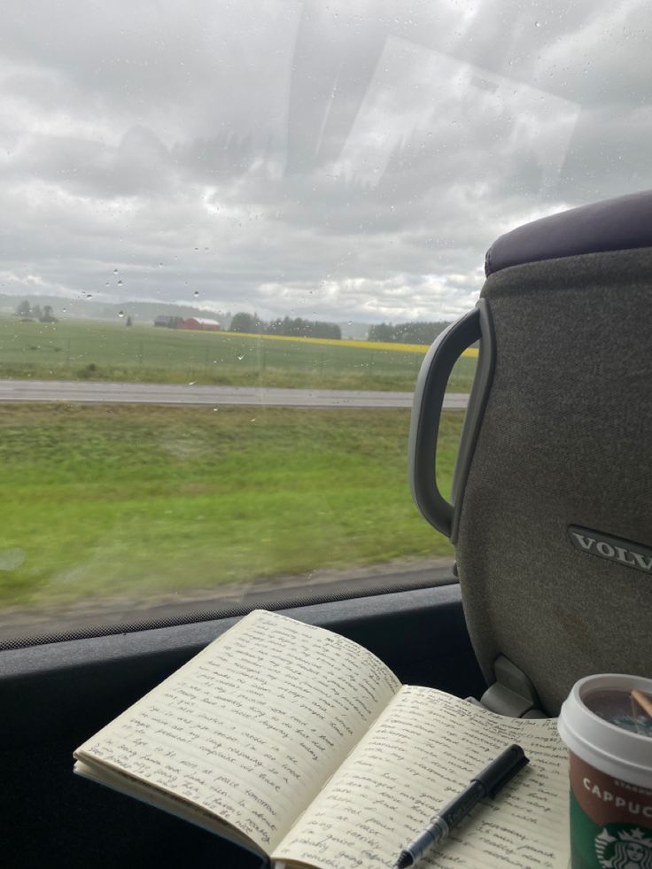 an open book sitting on top of a table next to a cup of coffee