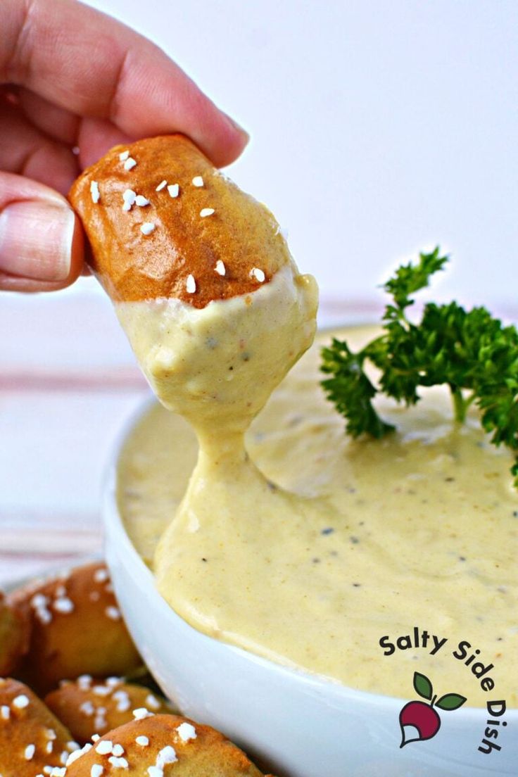 a person dipping something into a bowl of dip