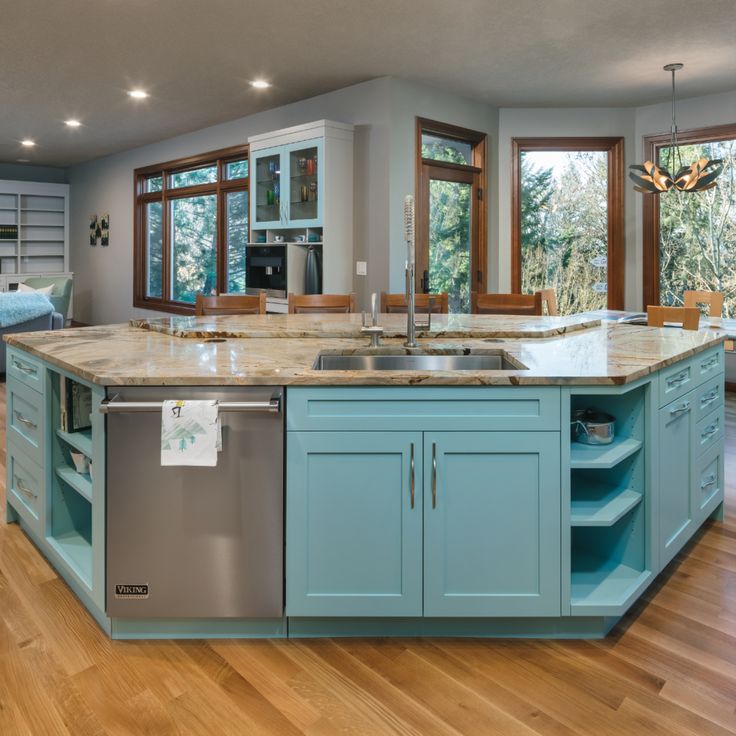 a large kitchen with blue cabinets and stainless steel dishwasher in it's center island