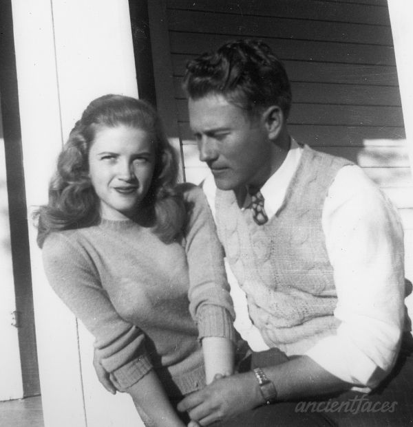 an old black and white photo of a man and woman sitting on the porch together