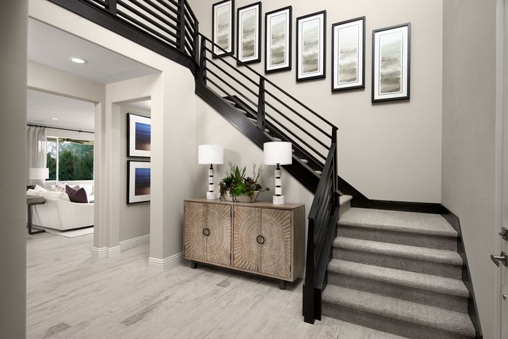 an entry way with stairs and pictures on the wall